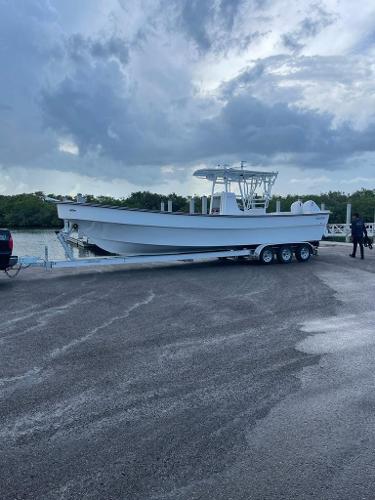 Slide: The Image of 2022 Panga Eduardoño Corvina 32 ft boat on a trailer by the water. - 14
