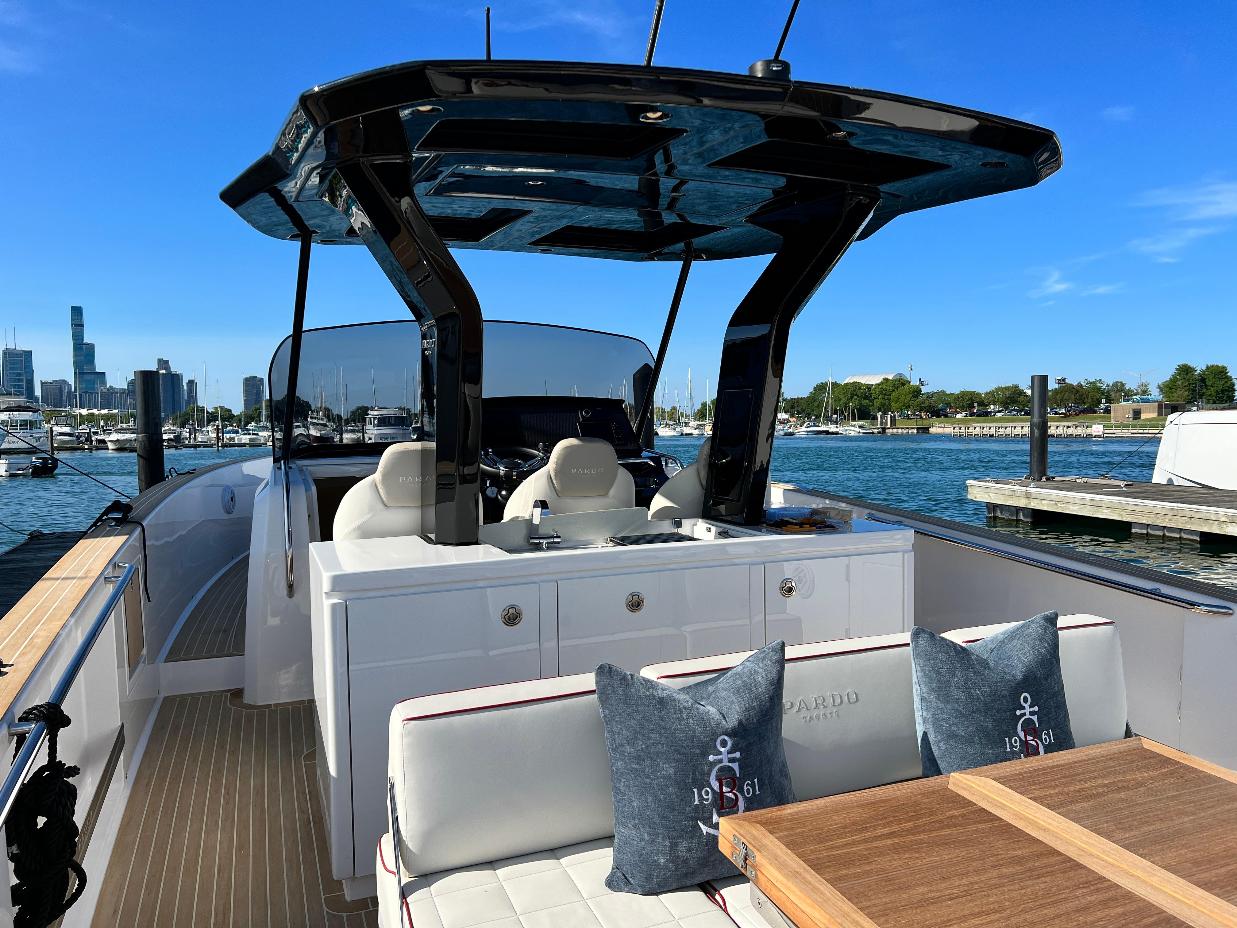 Slide: The Image of 2025 Pardo Yachts 38 Outboard, luxury boat interior at marina, clear blue sky. - 11
