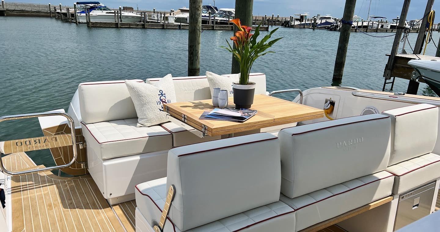 Slide: The Image of 2025 Pardo Yachts 38 Outboard with elegant seating and table, docked at marina. - 12