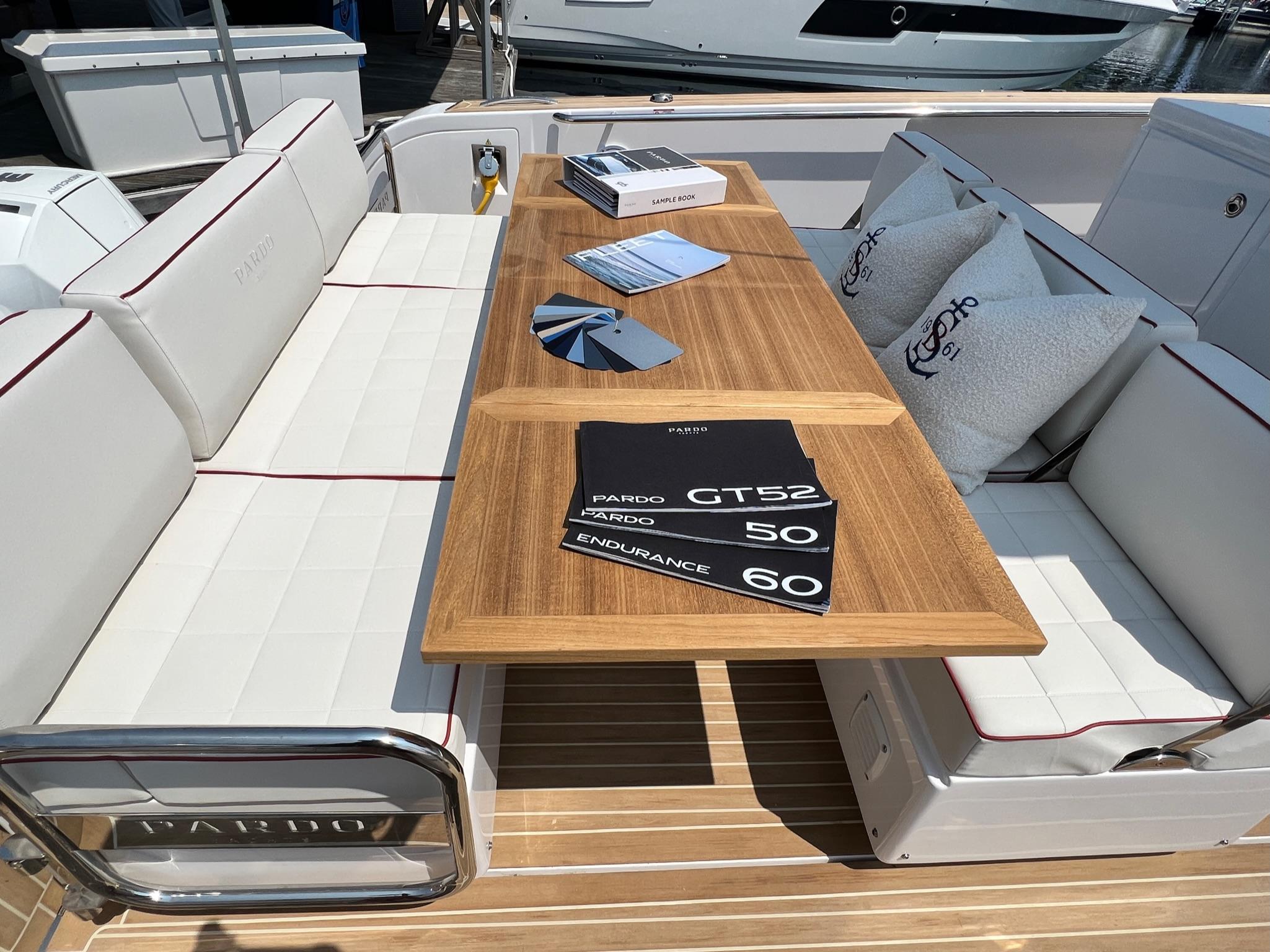 Slide: The Image of Luxury seating area on 2025 Pardo Yachts 38 Outboard with brochures and cushions. - 13
