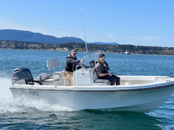 Slide: The Image of 2023 Parker 1801 Center Console boat cruising on a lake with two passengers. - 0