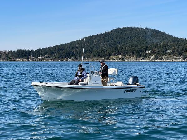 Slide: The Image of 2023 Parker 1801 Center Console boat on a scenic lake with two people onboard. - 1