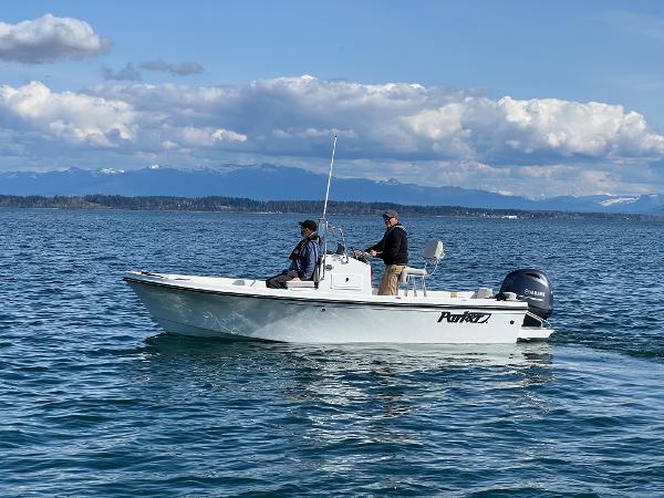 Slide: The Image of 2023 Parker 1801 Center Console boat on open water with two people onboard. - 2