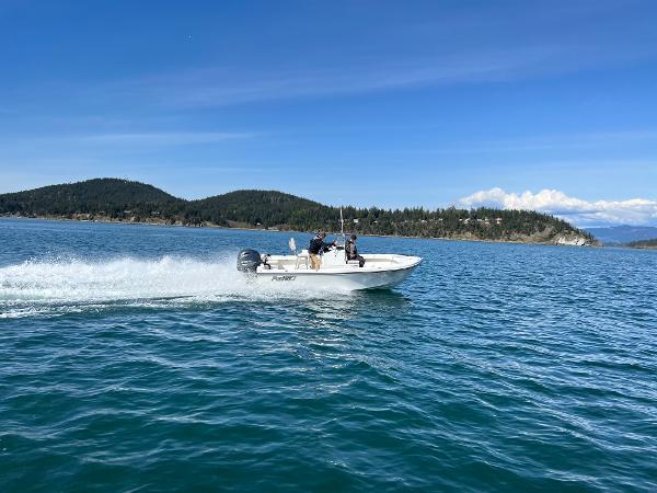 Slide: The Image of 2023 Parker 1801 Center Console boat cruising on a scenic lake with mountains in the background. - 6