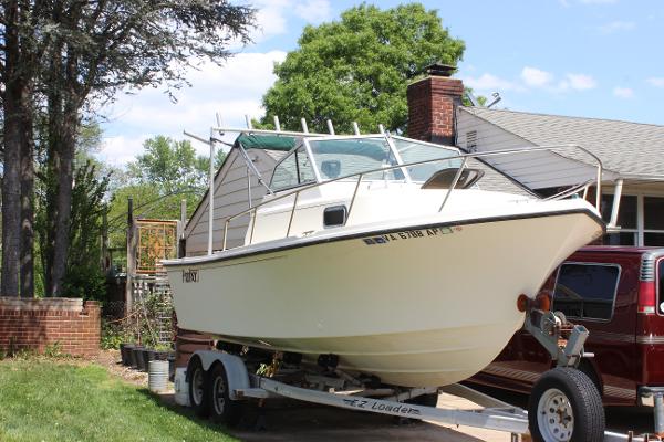 Slide: The Image of 1996 Parker 2110 Walkaround boat on a trailer in a residential driveway. - 1