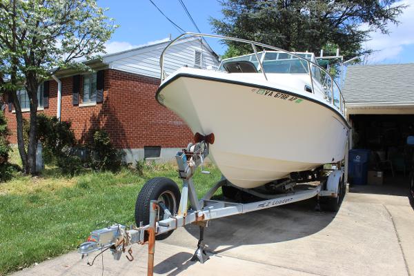 Slide: The Image of 1996 Parker 2110 Walkaround boat on trailer in driveway. - 10
