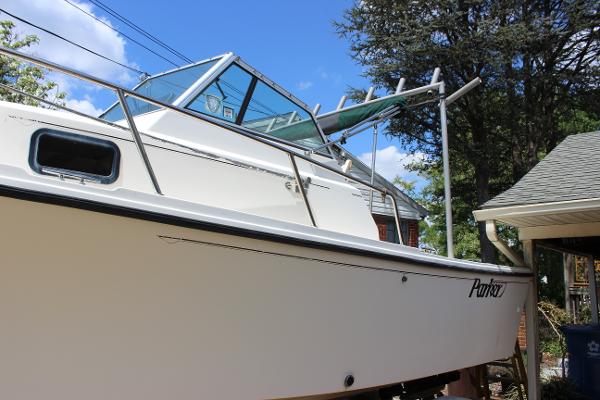 Slide: The Image of 1996 Parker 2110 Walkaround boat docked near a house, side view. - 12