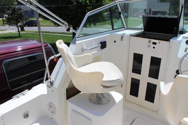 Slide: The Image of 1996 Parker 2110 Walkaround boat cockpit with white captain's chair and control panel. - 15