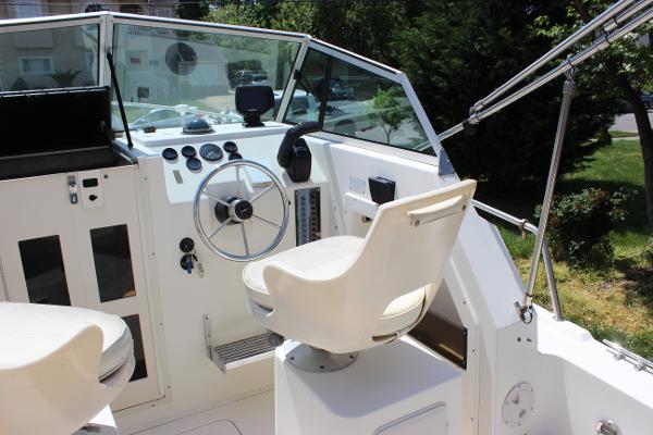 Slide: The Image of 1996 Parker 2110 Walkaround boat cockpit with steering wheel and seating. - 16