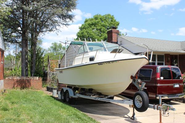 Slide: The Image of 1996 Parker 2110 Walkaround boat on a trailer in a residential driveway. - 2