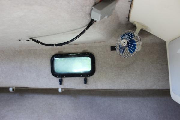 Slide: The Image of Interior cabin of a 1996 Parker 2110 Walkaround boat with a small window and fan. - 28