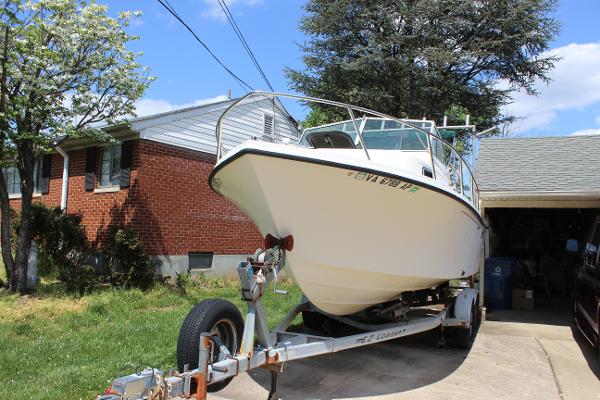 Slide: The Image of 1996 Parker 2110 Walkaround boat on trailer in driveway near brick house. - 9