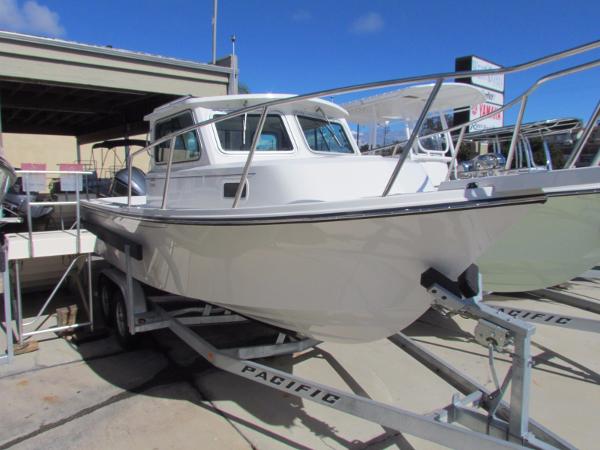 Slide: The Image of 2021 Parker 2320 SL SC boat on a trailer at a marina. - 1