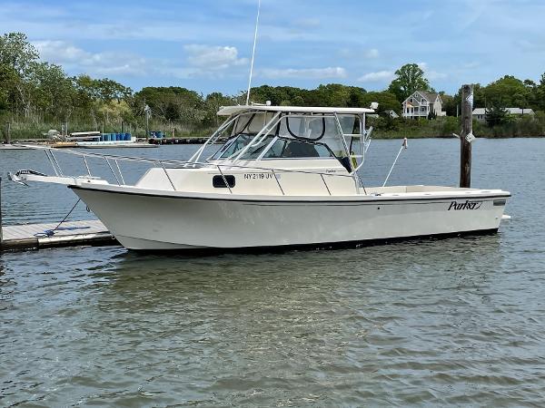Slide: The Image of 2002 Parker 2510 Walkaround boat docked on a calm river. - 0