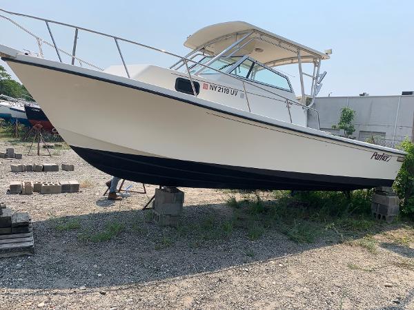 Slide: The Image of 2002 Parker 2510 Walkaround boat on blocks in a yard. - 1