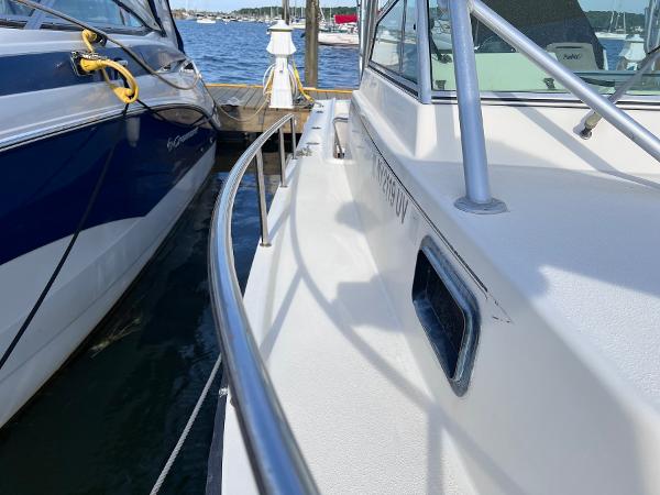Slide: The Image of 2002 Parker 2510 Walkaround boat docked beside another vessel. - 13