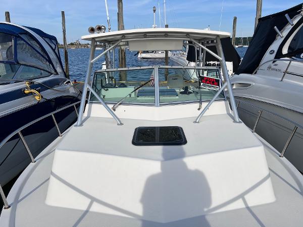 Slide: The Image of 2002 Parker 2510 Walkaround boat docked between two other boats. - 14