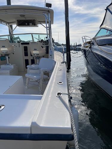 Slide: The Image of 2002 Parker 2510 Walkaround boat docked beside another vessel. - 18