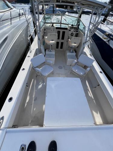Slide: The Image of 2002 Parker 2510 Walkaround boat with spacious deck and seating, docked at marina. - 3