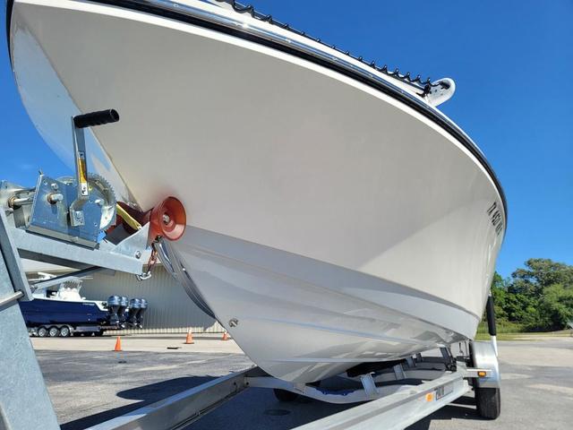 Slide: The Image of 2023 Pathfinder 2400 Open boat on trailer, viewed from below, clear blue sky background. - 4