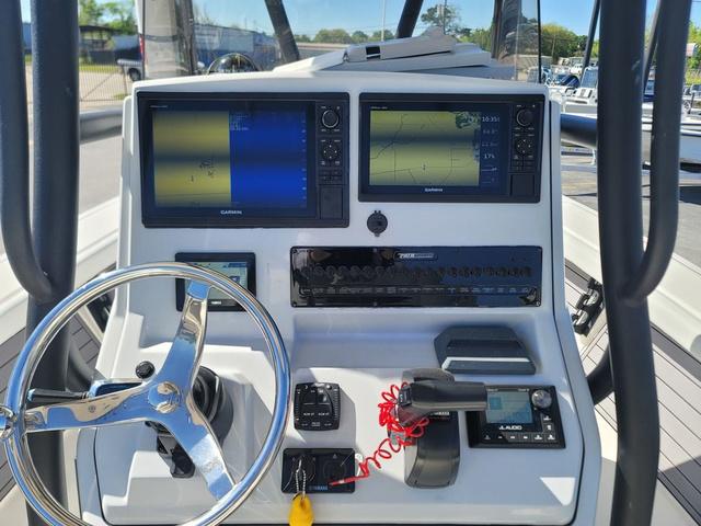 Slide: The Image of 2023 Pathfinder 2400 Open boat dashboard with dual Garmin displays and steering wheel. - 9
