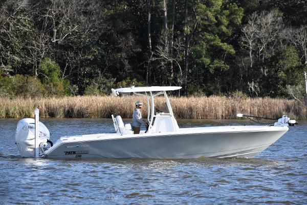 Slide: The Image of 2024 Pathfinder 2700 Open boat cruising on a calm river with forested background. - 0