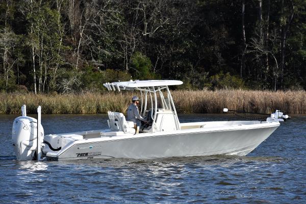Slide: The Image of 2024 Pathfinder 2700 Open boat cruising on a calm lake with forested background. - 1