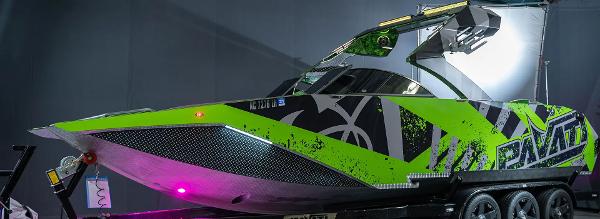 Slide: The Image of 2018 Pavati AL26 boat with vibrant green and black design on a trailer. - 0