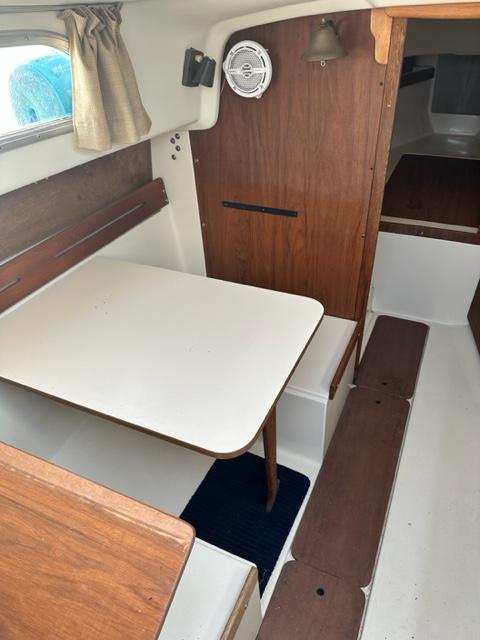 Slide: The Image of 1978 Pearson 26 sailboat interior with dining table and wooden accents. - 13