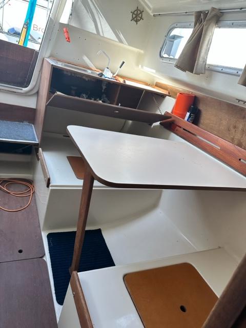 Slide: The Image of Interior of a 1978 Pearson 26 sailboat with a compact kitchen and dining area. - 19