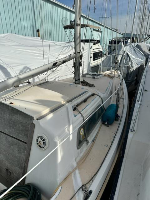 Slide: The Image of 1978 Pearson 26 sailboat docked, side view showing deck and mast. - 6