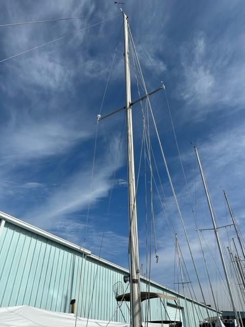 Slide: The Image of 1978 Pearson 26 sailboat mast against a blue sky with clouds. - 7