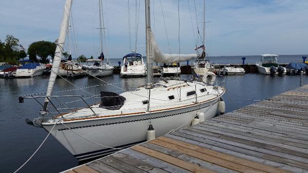 Slide: The Image of 1989 Pearson 31 sailboat docked at a marina with other boats. - 0