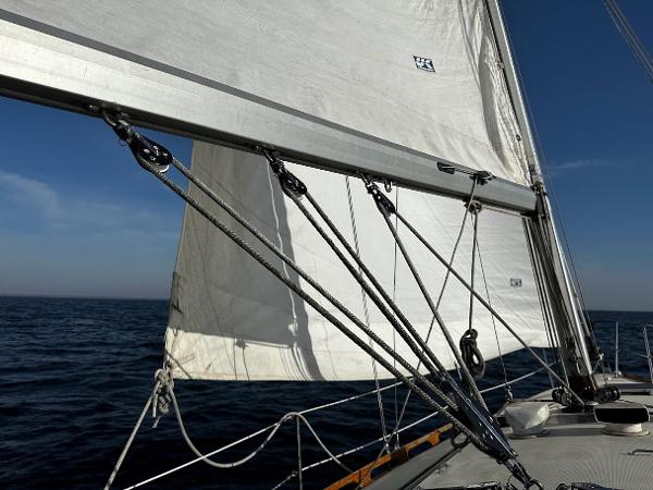Slide: The Image of Sailing on a 1989 Pearson 31 yacht with white sails against a clear blue sky. - 14