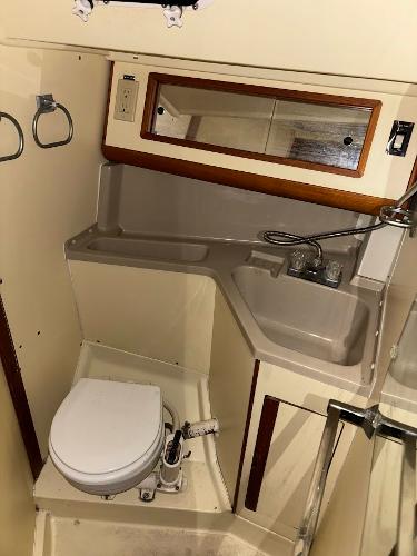 Slide: The Image of 1989 Pearson 31 sailboat bathroom with sink, mirror, and toilet. - 21