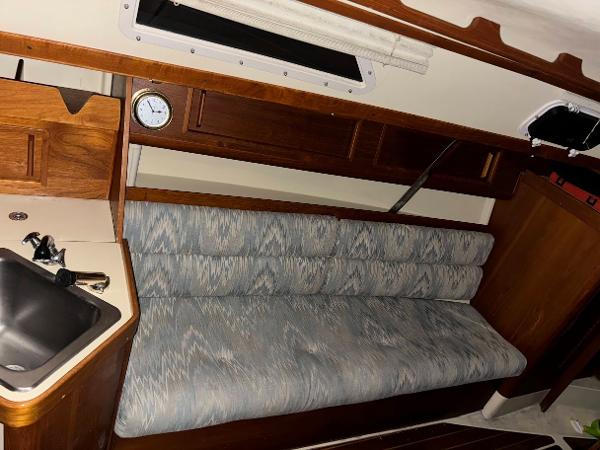 Slide: The Image of Interior of 1989 Pearson 31 sailboat with sink, clock, and cushioned seating. - 22