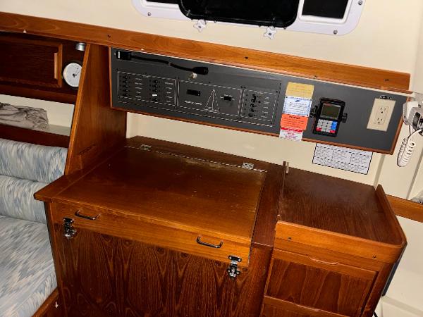 Slide: The Image of Navigation station of a 1989 Pearson 31 sailboat with control panel and wooden cabinetry. - 25