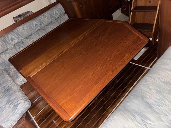 Slide: The Image of Interior of 1989 Pearson 31 sailboat with wooden table and cushioned seating. - 33