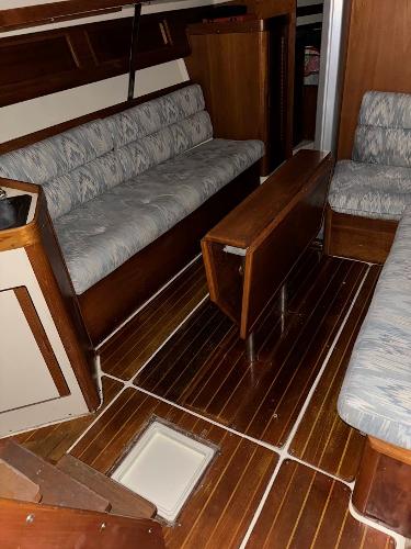 Slide: The Image of Interior of 1989 Pearson 31 sailboat with wooden flooring and cushioned seating. - 34