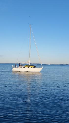 Slide: The Image of Pearson 31 sailboat from 1989 on calm blue water under clear sky. - 5