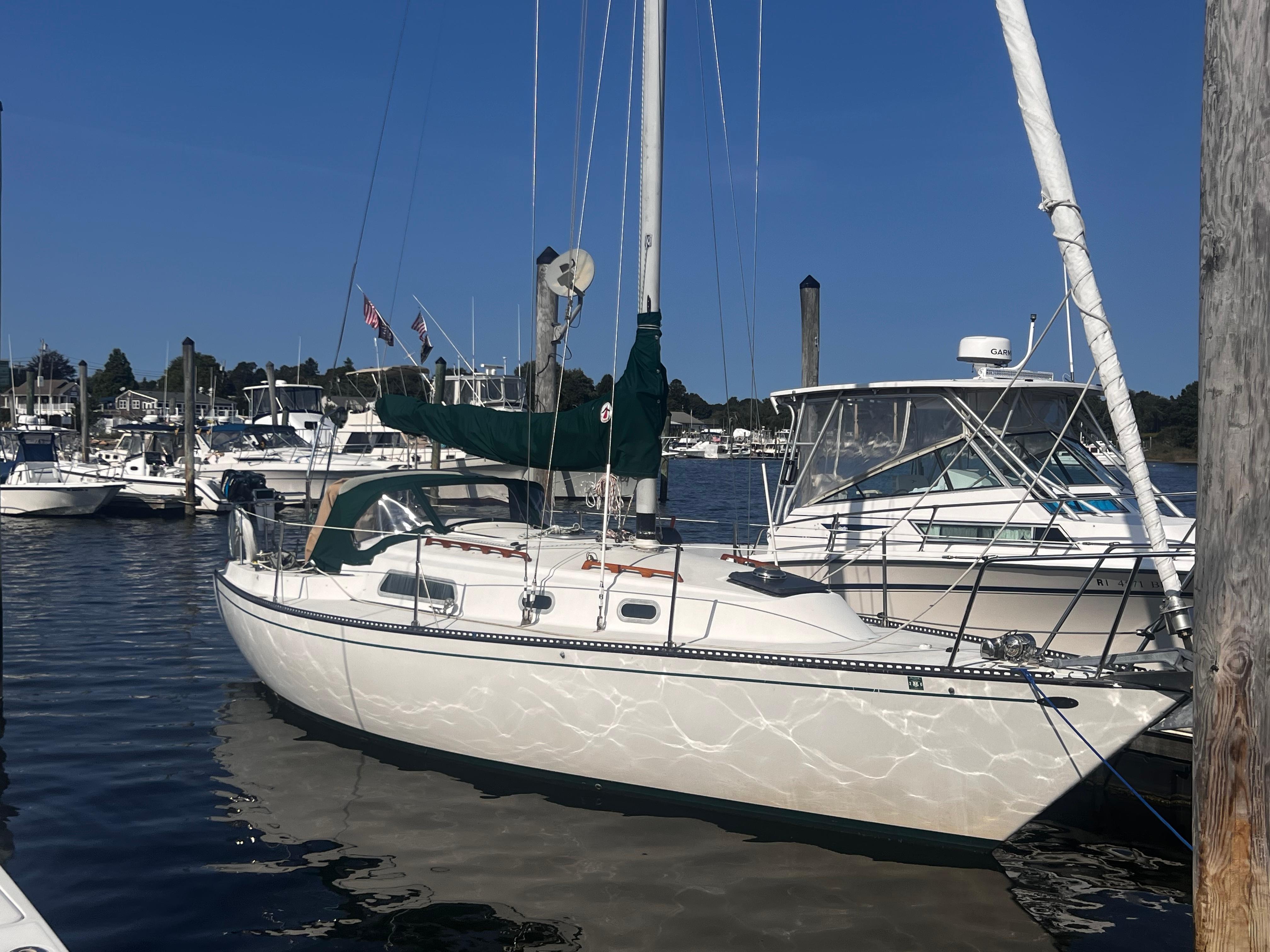 Slide: The Image of 1980 Pearson 32 sailboat docked in a marina under clear blue skies. - 1