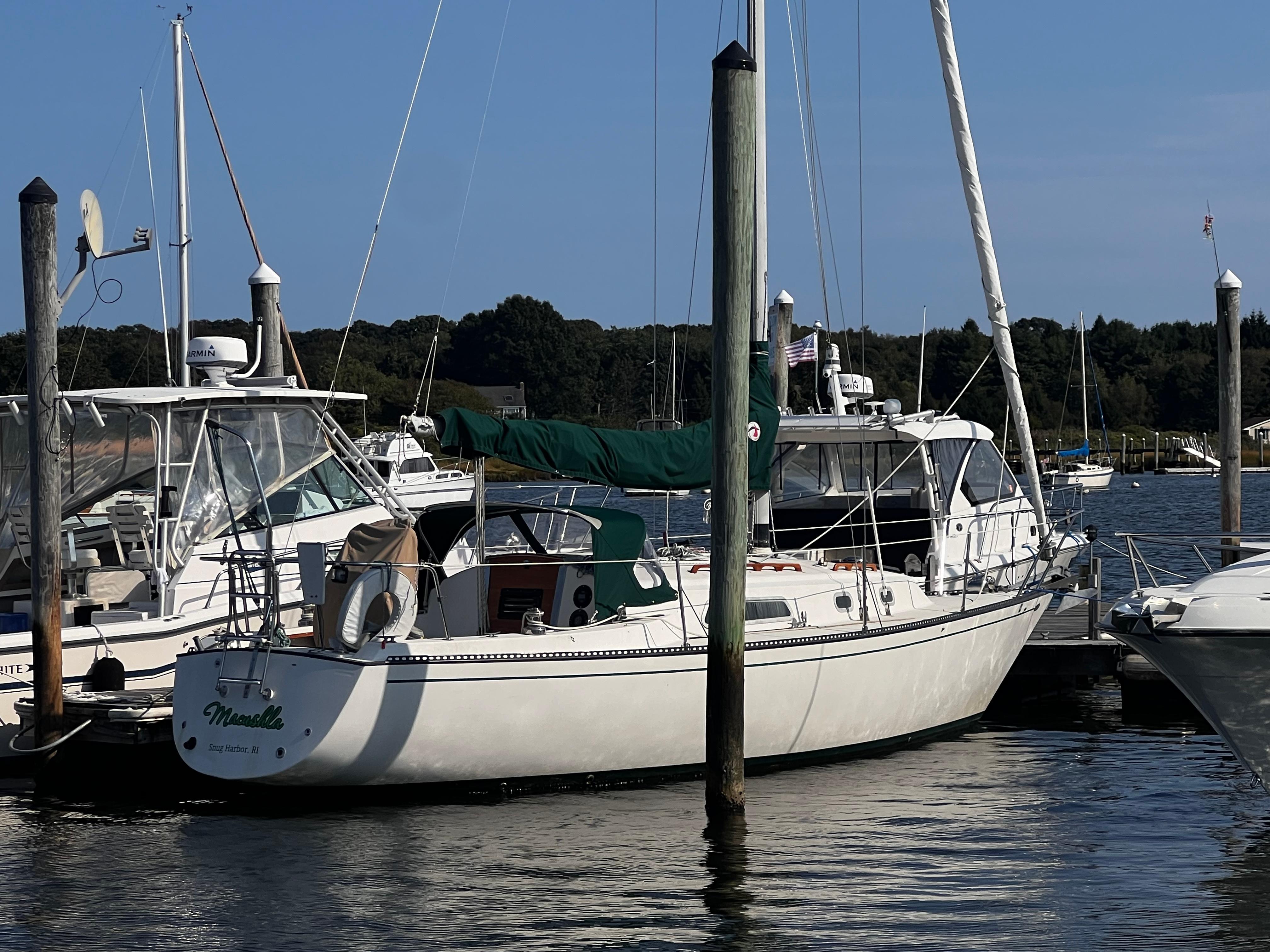 Slide: The Image of 1980 Pearson 32 sailboat docked at marina, surrounded by other boats. - 2
