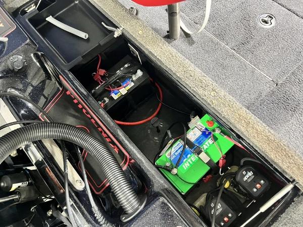 Slide: The Image of 2022 Phoenix 919 Pro XP boat battery compartment with wiring and storage. - 23