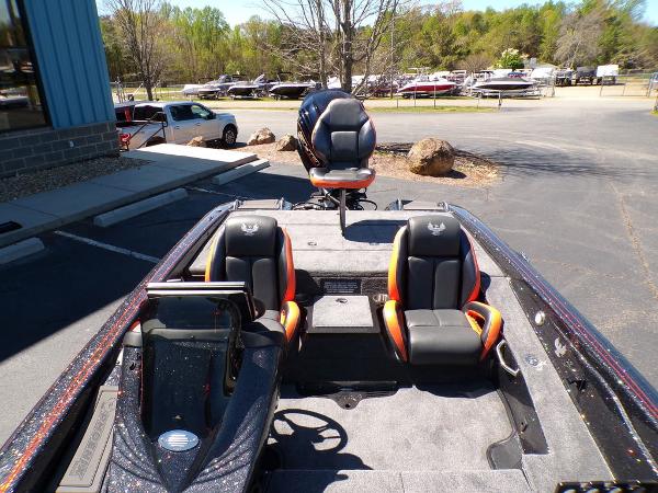Slide: The Image of 2024 Phoenix 919 Pro XP boat with black and orange seats in a parking lot. - 12