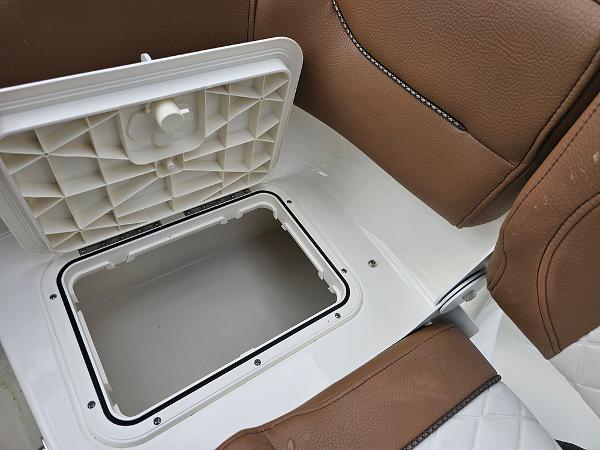 Slide: The Image of 2025 Pioneer 202 Islander boat storage compartment with open lid and brown seating. - 10