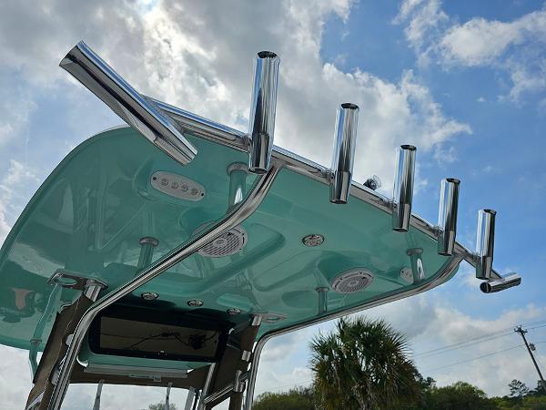 Slide: The Image of 2025 Pioneer 202 Islander boat T-top with rod holders against a cloudy sky. - 13