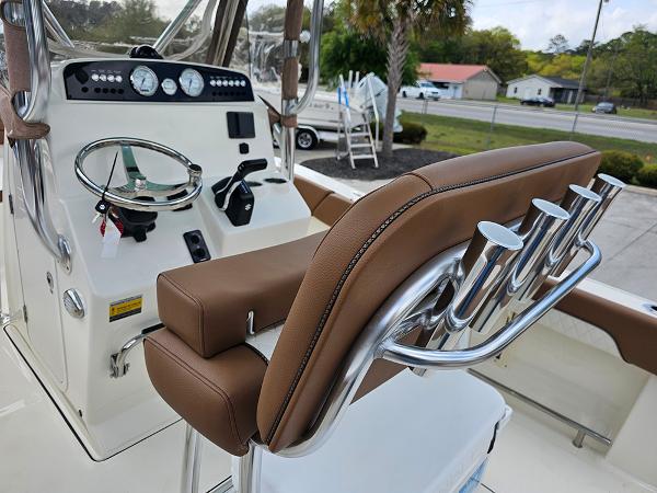 Slide: The Image of 2025 Pioneer 202 Islander boat interior with brown seating and chrome rod holders. - 14