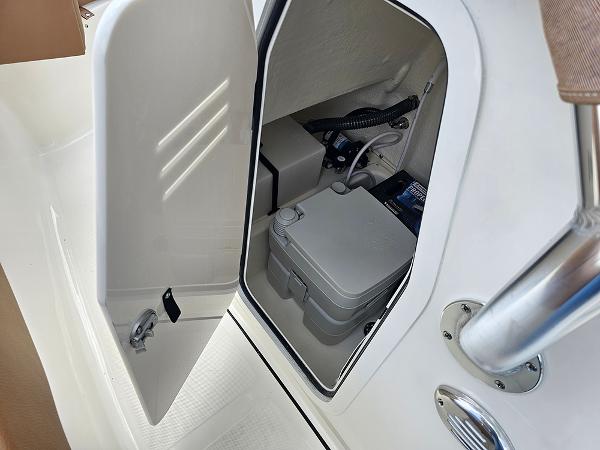 Slide: The Image of 2025 Pioneer 202 Islander boat storage compartment with equipment and portable toilet. - 17