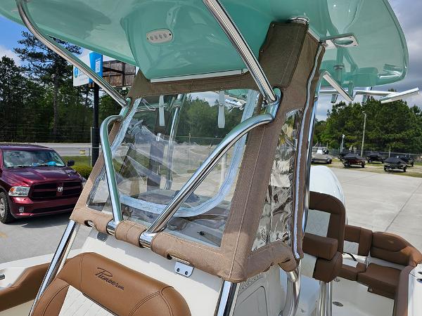 Slide: The Image of 2025 Pioneer 202 Islander boat with teal canopy and brown seating, parked outdoors. - 21