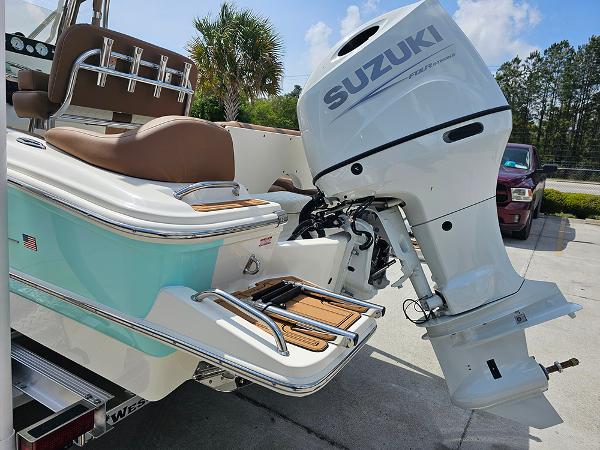 Slide: The Image of 2025 Pioneer 202 Islander boat with Suzuki outboard motor, parked outdoors. - 27